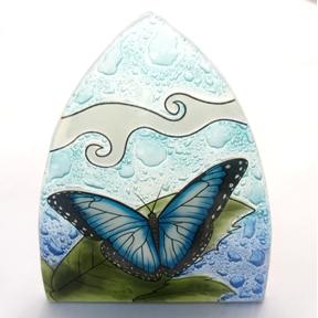 A blue butterfly on a glass nightlight