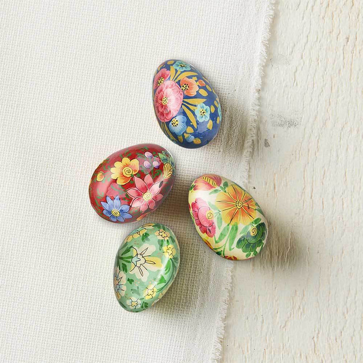 Five colorful floral-patterned Easter Eggs on a textured white surface