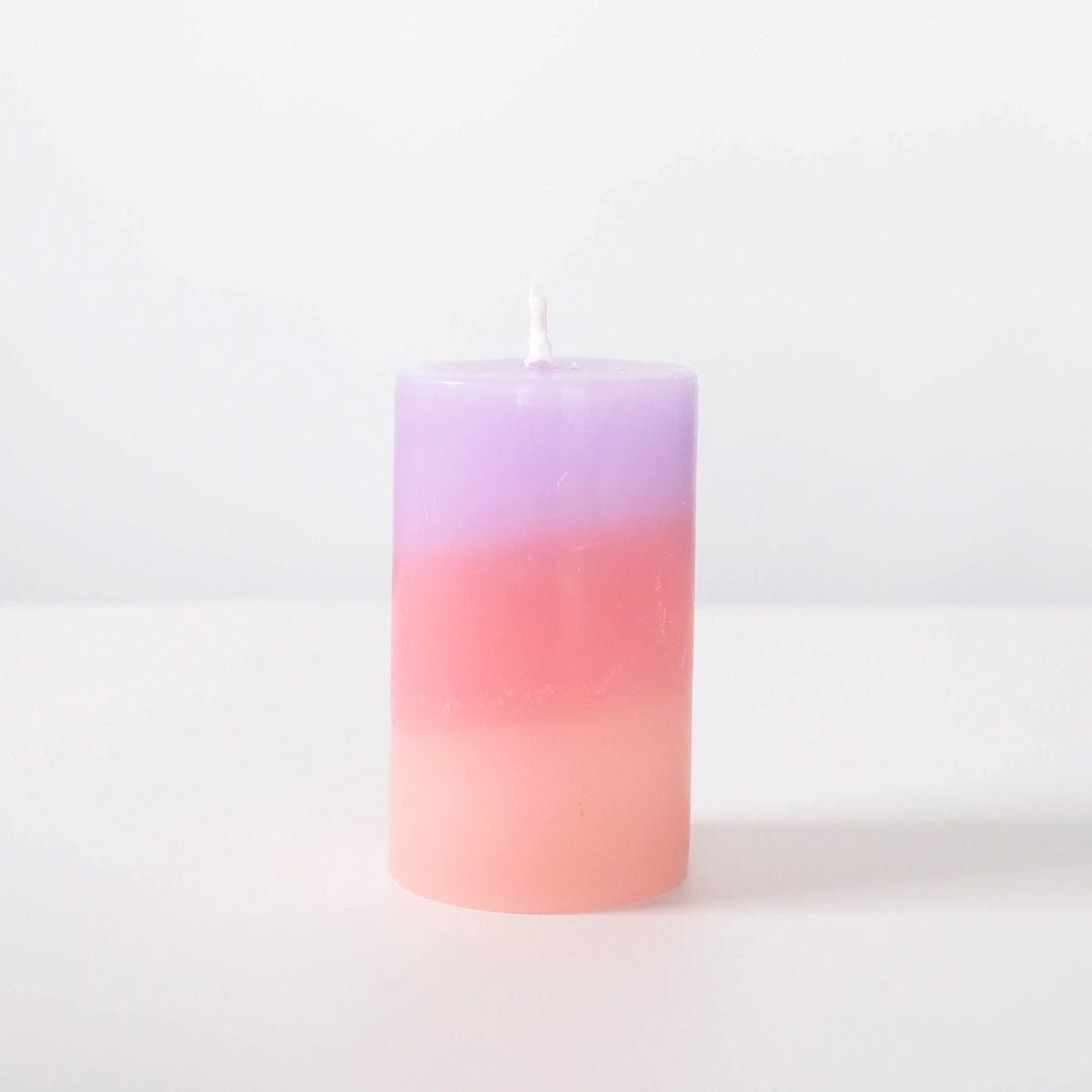 Gradient pink to purple candle on a white background