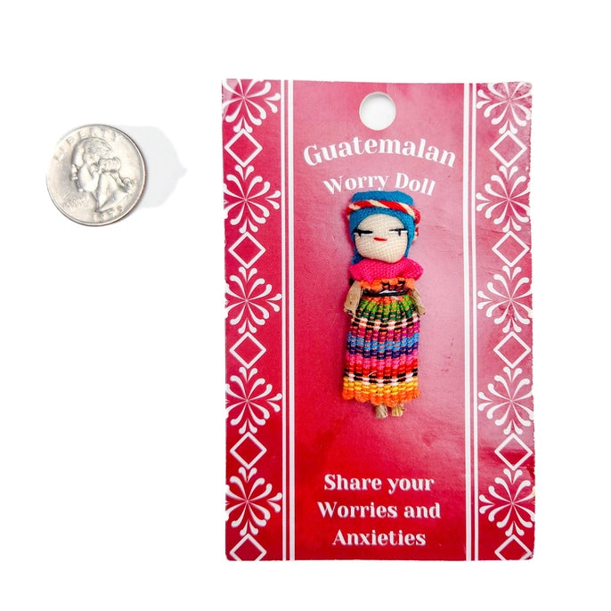 Guatemalan worry doll on a pink packaging with decorative patterns and text.