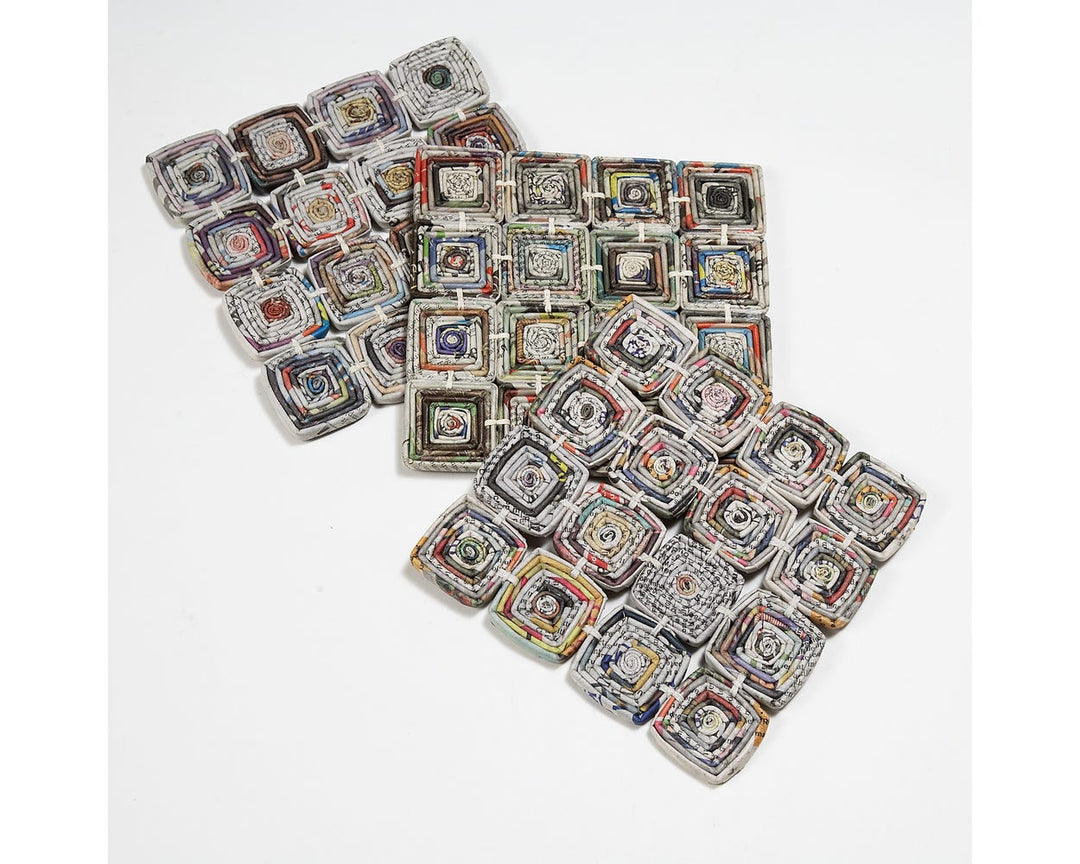 Square trivet made from recycled newspaper on a white background