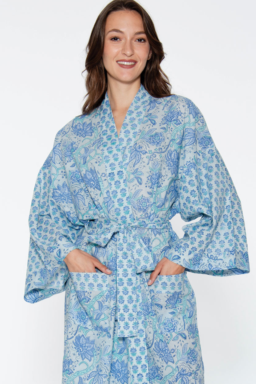 Woman wearing a blue floral patterned robe on a white background