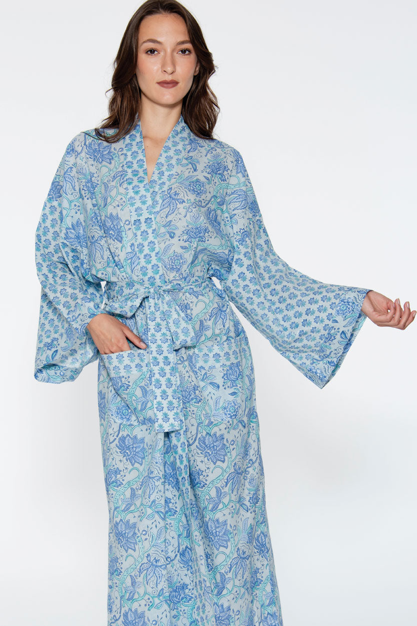 Woman wearing a blue floral patterned robe on a white background