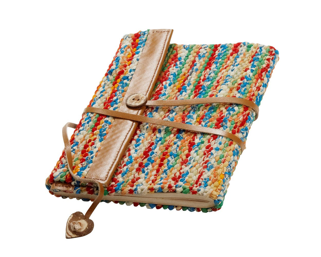 Colorful woven notebook with leather trim on a white background