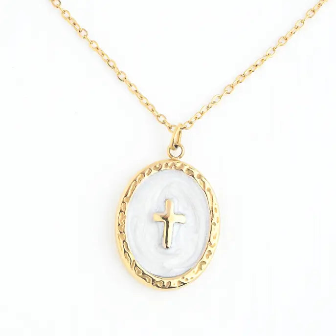 A gold chain necklace with an oval pendant featuring a textured gold border, a white inlay, and a small gold cross in the center, shown on a plain white background.