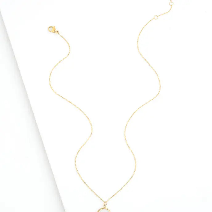 A delicate gold chain necklace with a small circular pendant, displayed on a clean white background.