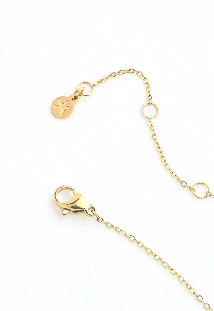 Gold chain extender strap with a lobster clasp, a small hanging charm, and two adjustable rings on a white background.