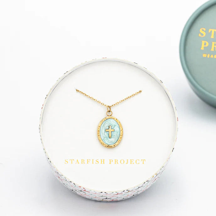 Gold necklace with a turquoise pendant in a clear display case, branded 'Starfish Project'.
