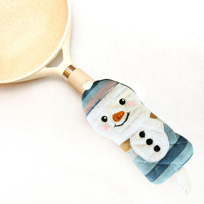 skillet handle holder with snowman design on a white background