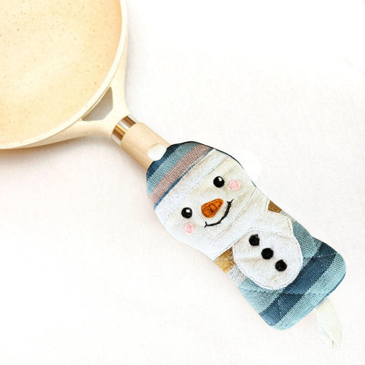skillet handle holder with snowman design on a white background