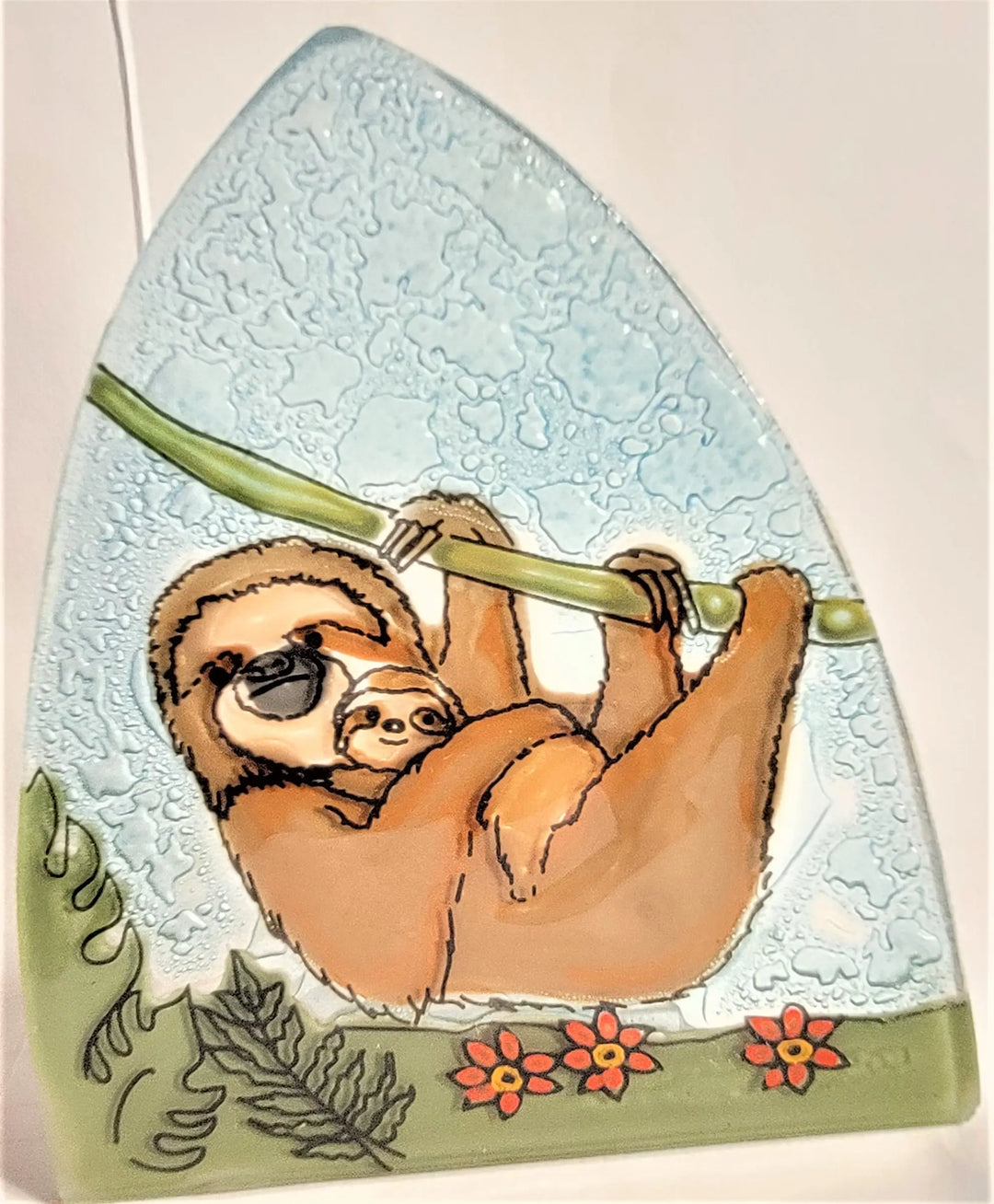 a mother sloth and baby on a glass nightlight on a cream background