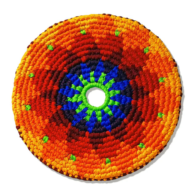 Colorful circular woven flying disk with concentric patterns on a white background