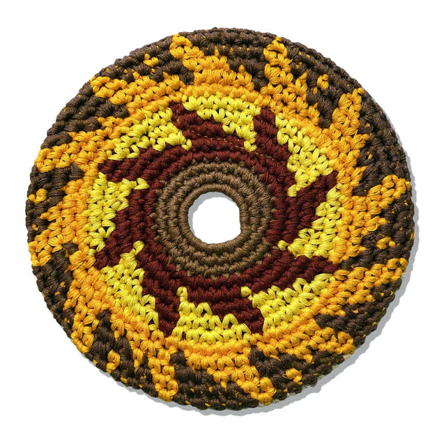 Round crochet flying disk with a sunflower pattern in brown, yellow, and red on a white background