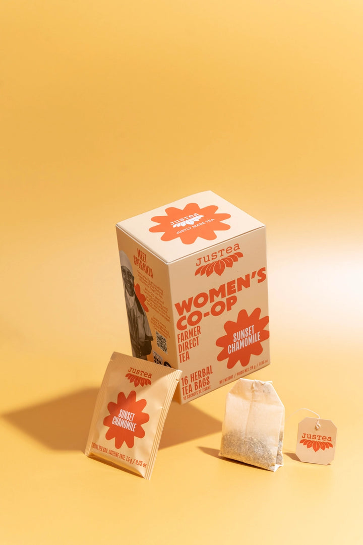 Justea Women's Co-op tea packaging on a yellow background