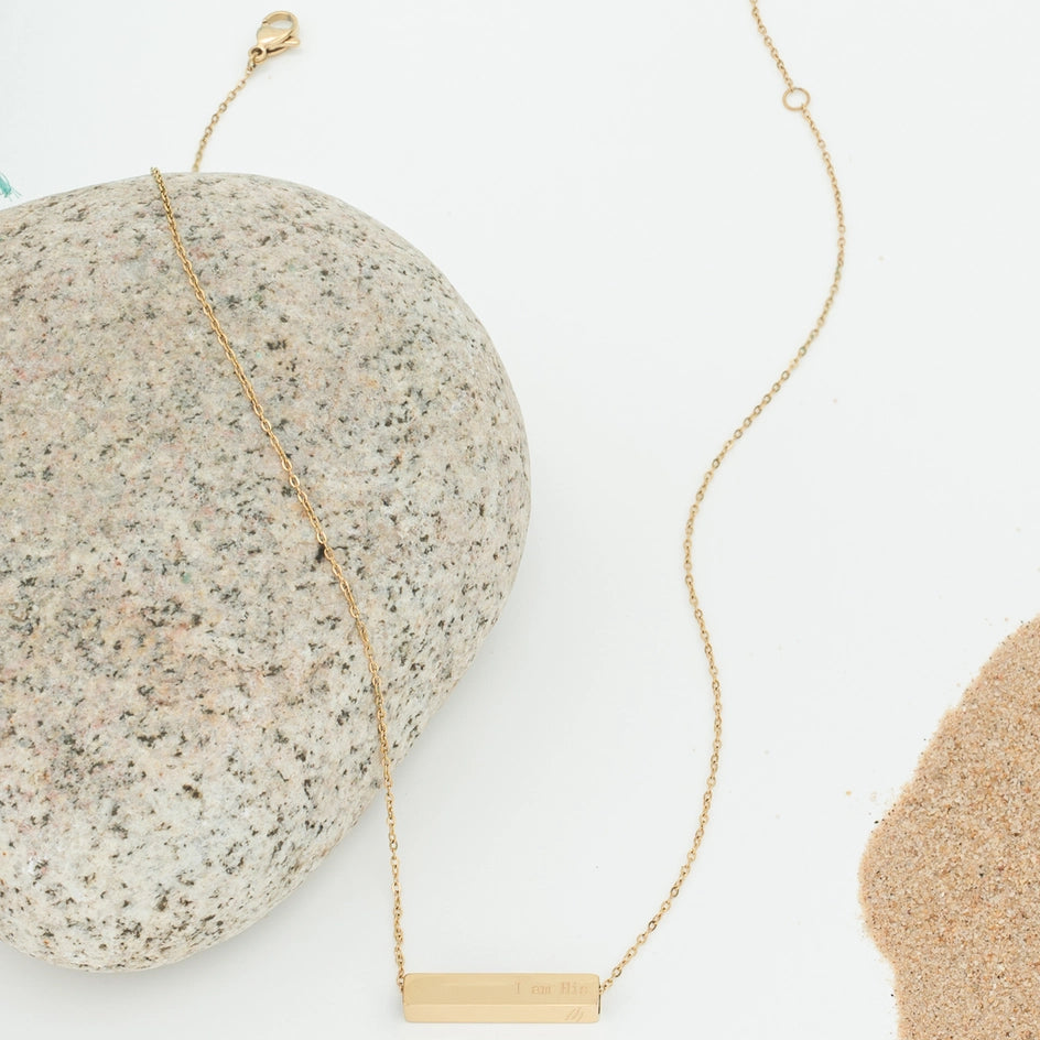Gold necklace on a textured stone surface
