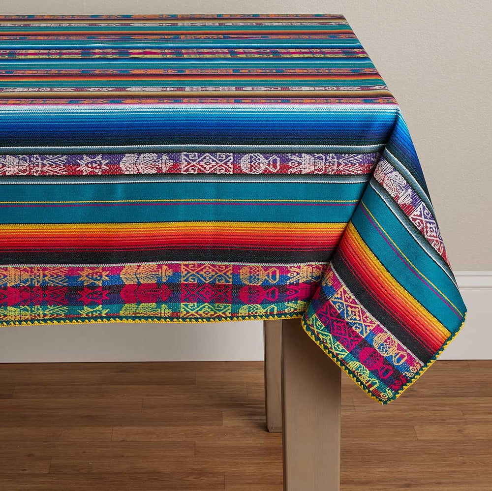 Colorful striped tablecloth with geometric patterns on a wooden table.
