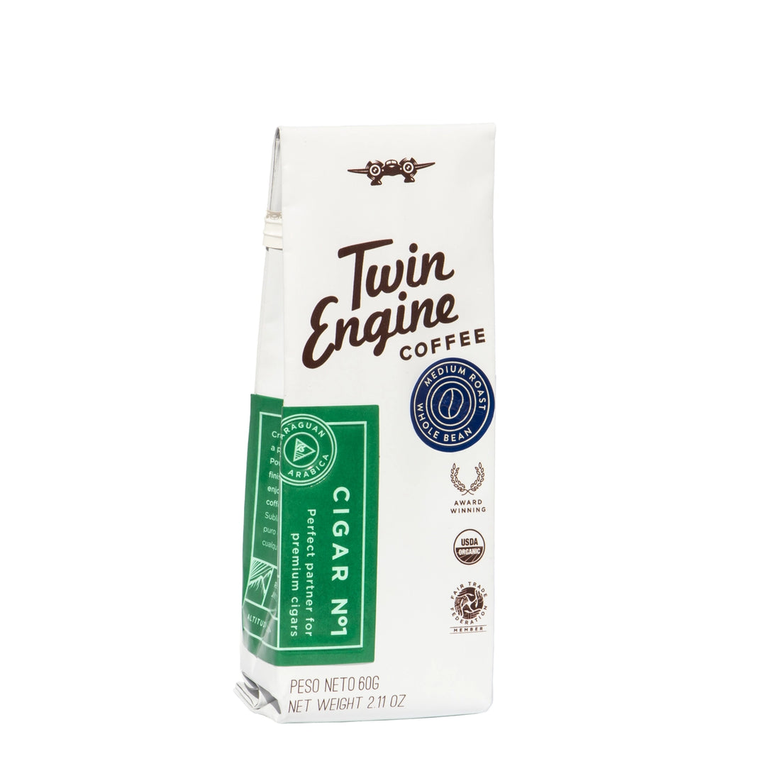 A package of Twin Engine Coffee Cigar Net in a white paper bag with brown script lettering, a green side panel, and several certification logos, shown on a plain white background.