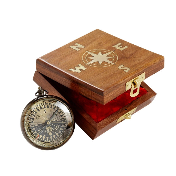 Brass compass and wooden box with compass design on a white background