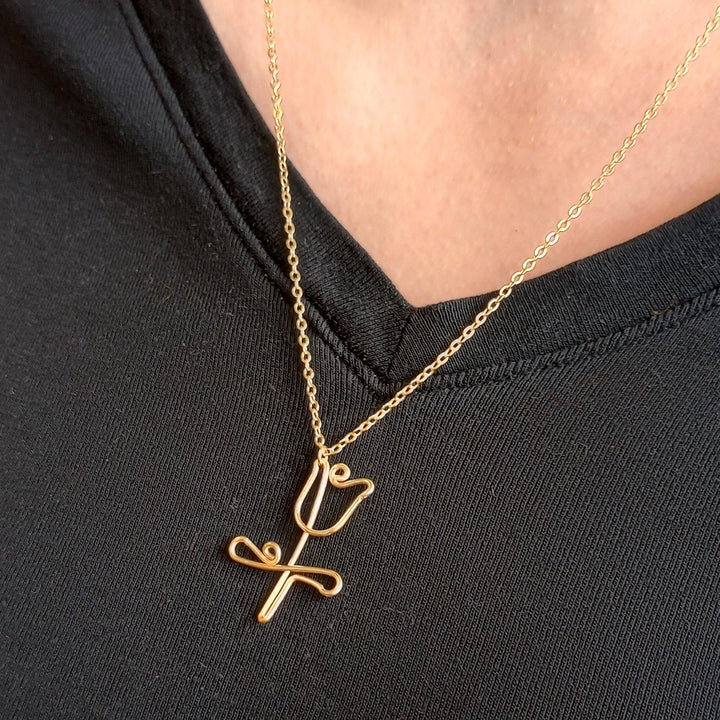 Gold necklace with a tulip pendant on a black background