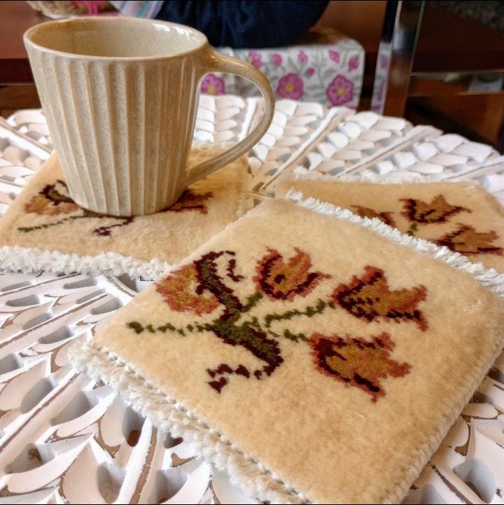 Coasters with tulip design on a decorative table with a cream mug