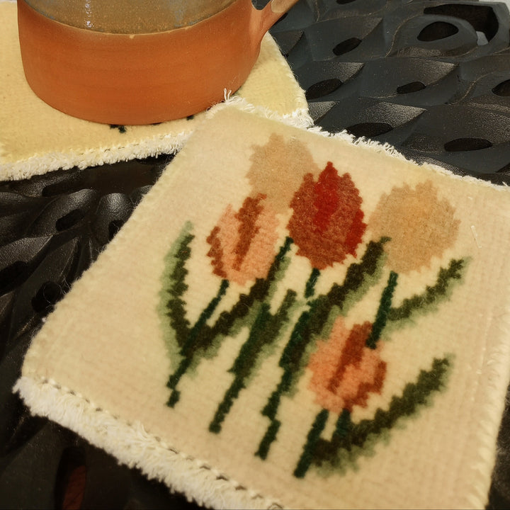 Ceramic mug on a coaster with tulip design on a dark table