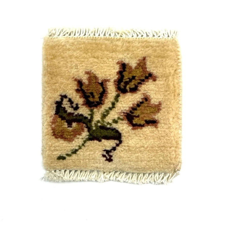 Square woven rug coaster with tulip design on a beige background
