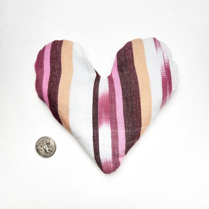 Heart-shaped striped eye bag with pink, white, and brown colors on a white background.
