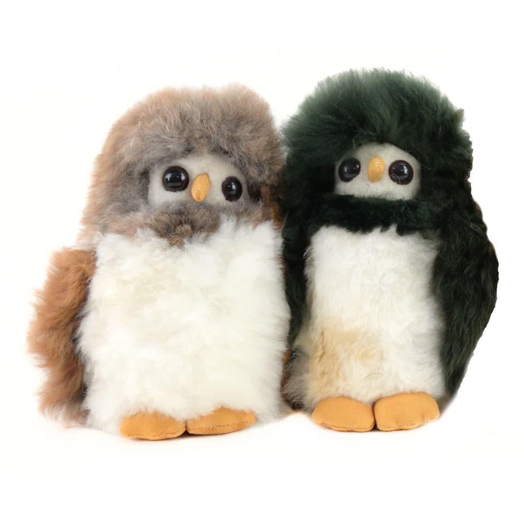 Two plush alpaca toy owls with alpaca fur, one in beige and the other in green, standing side by side.