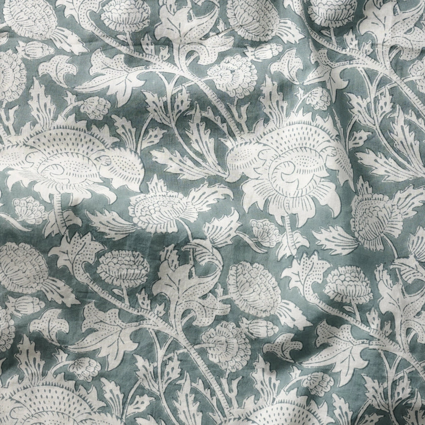 Floral patterned fabric with white flowers on a teal background