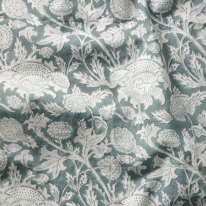 Floral patterned fabric with white flowers on a teal background