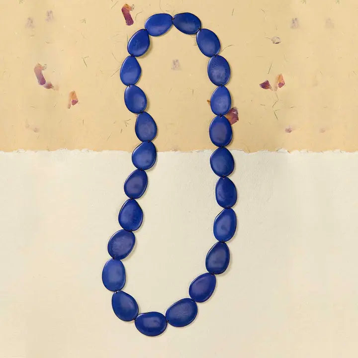 Blue beaded necklace on a beige background