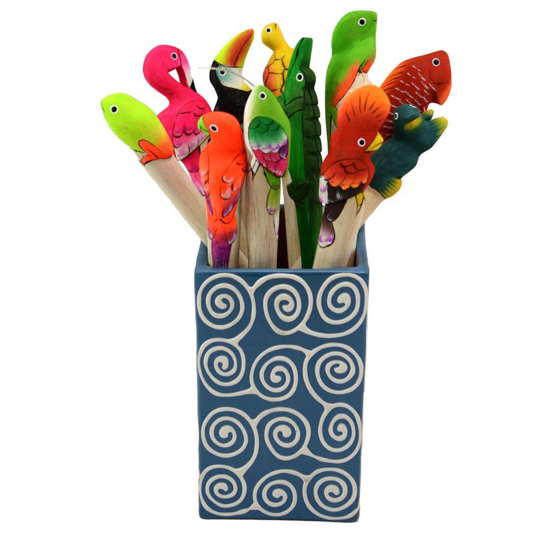 A collection of colorful hand-carved and hand-painted balsa wood animal pens displayed in a container with a spiral pattern.