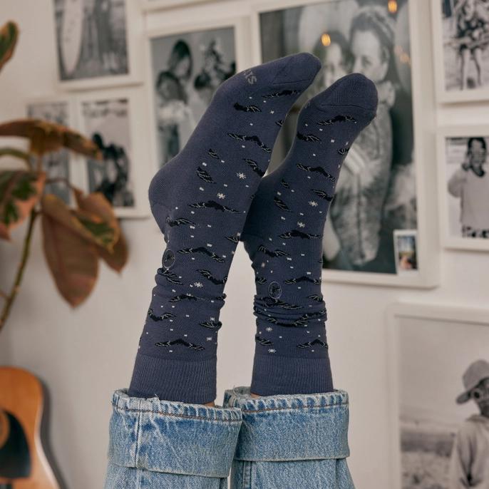A pair of dark blue socks with a pattern of bats and stars.