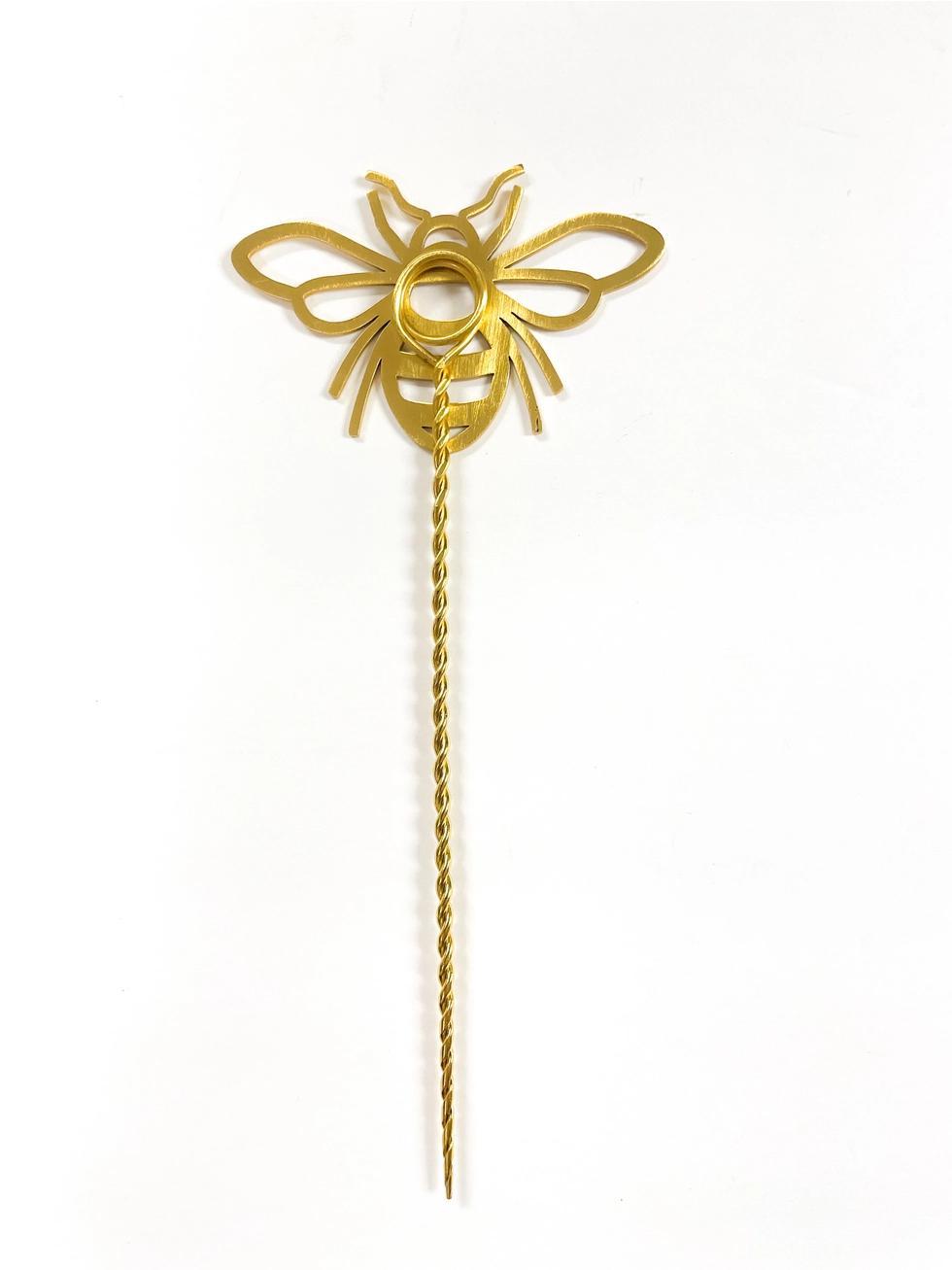 Gold-colored decorative plant stick on a white background