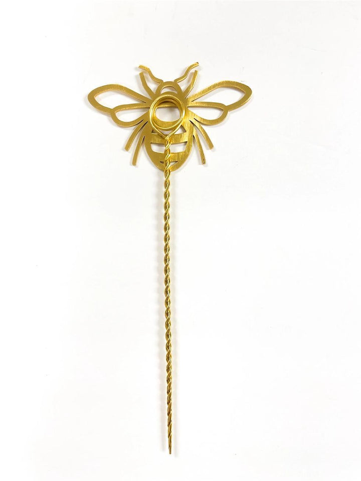 Gold-colored decorative plant stick on a white background