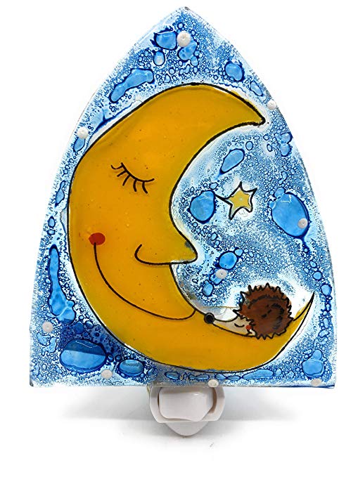 A hand-painted glass night light featuring a smiling yellow crescent moon and a small brown hedgehog on a textured blue and white background, shown on a white plastic holder against a white studio background.