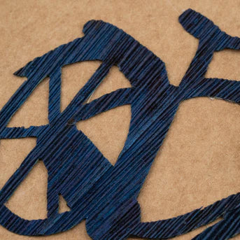 Bicycle-shaped cutout with cornhusk on a brown background