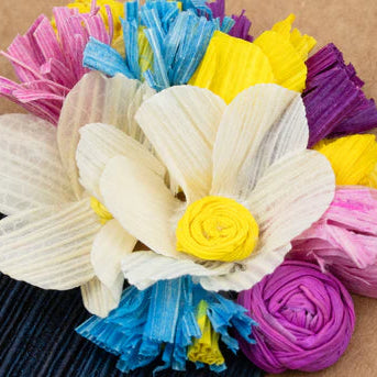 Colorful cornhusk flowers on a brown background