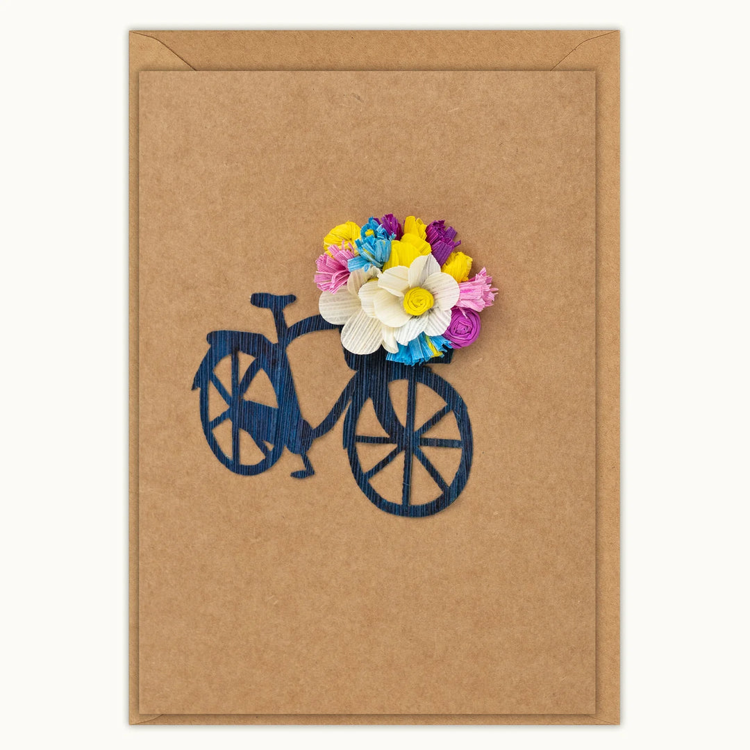 Card with a bicycle and colorful flowers on a brown background