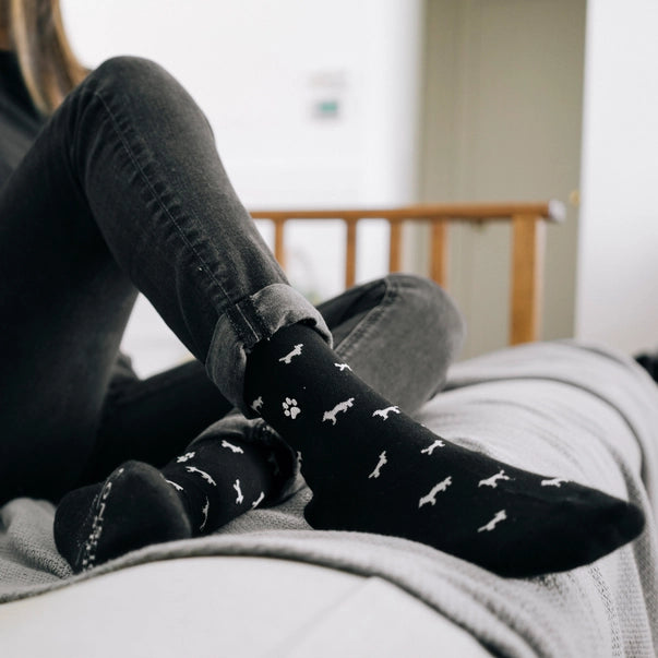 a woman wearing black crew sock with white dogs 