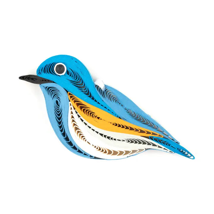 A stylized bird-shaped decorative ornament with layered curved stripes in blue, black, orange, white, and brown on a plain white background.