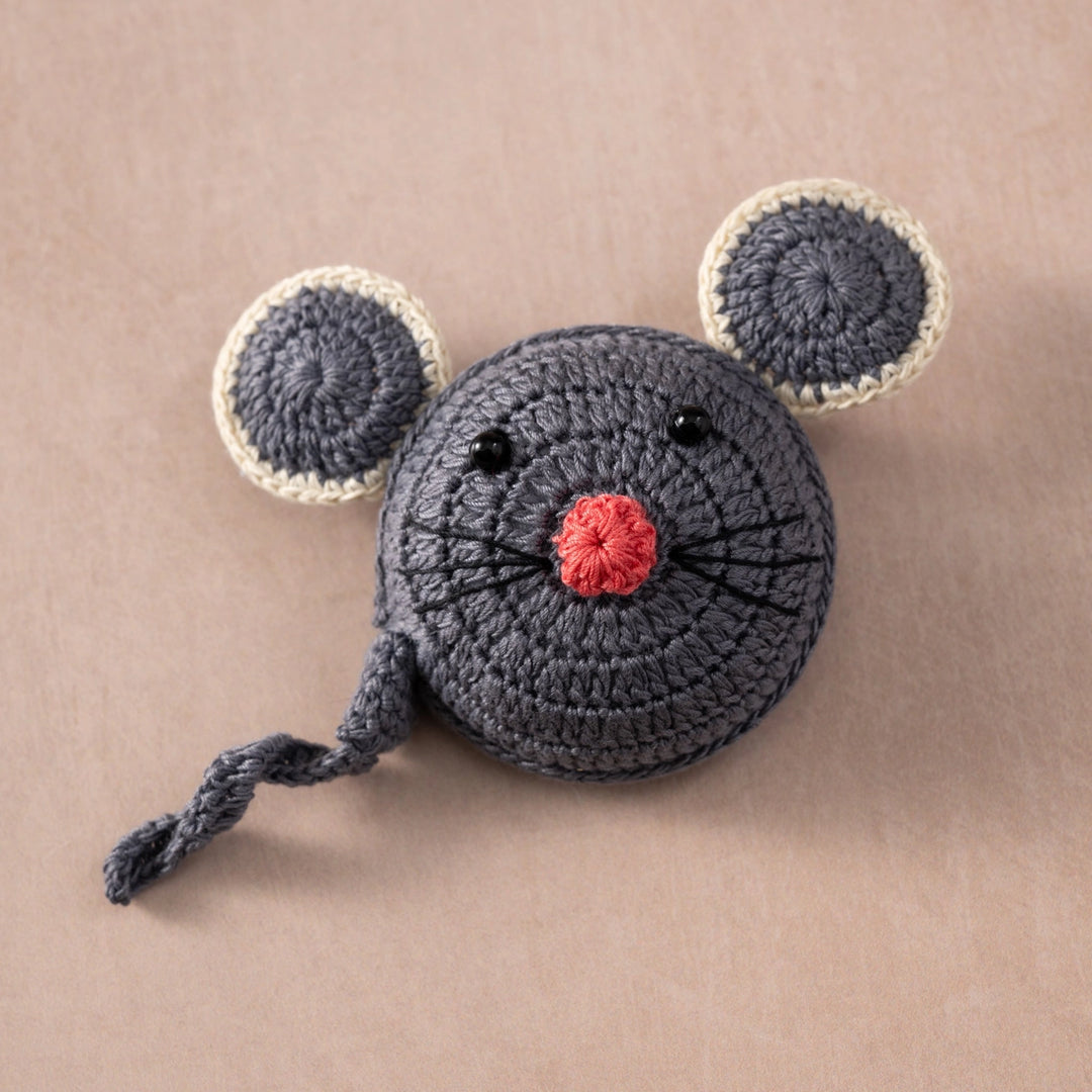 Crocheted mouse measuring tape on a beige background