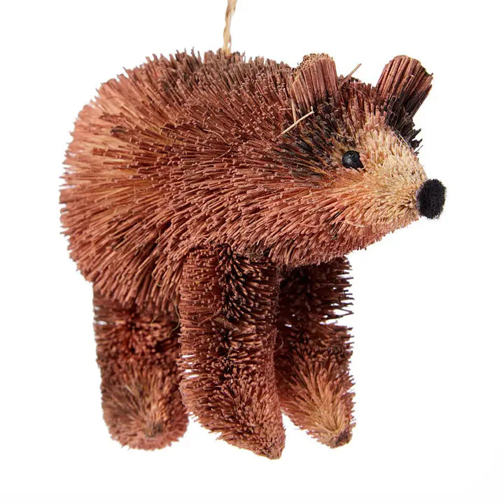 A small brown brush-bear style hanging ornament with a hanging string, photographed on a plain white background.