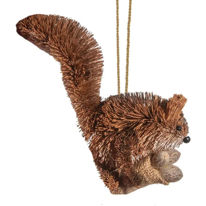 A brown buri fur squirrel Christmas ornament with a long bushy tail, hanging from a tan string against a plain white background.