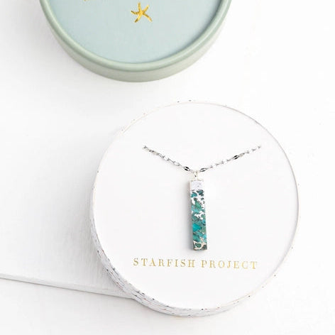 Starfish Project necklace in a round, light blue box on a white background