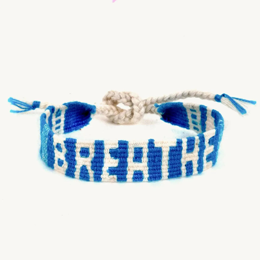 Blue and white braided bracelet with word "BREATHE" on a white background