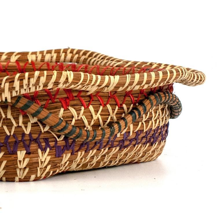 Handwoven basket with multicolored patterns on a white background