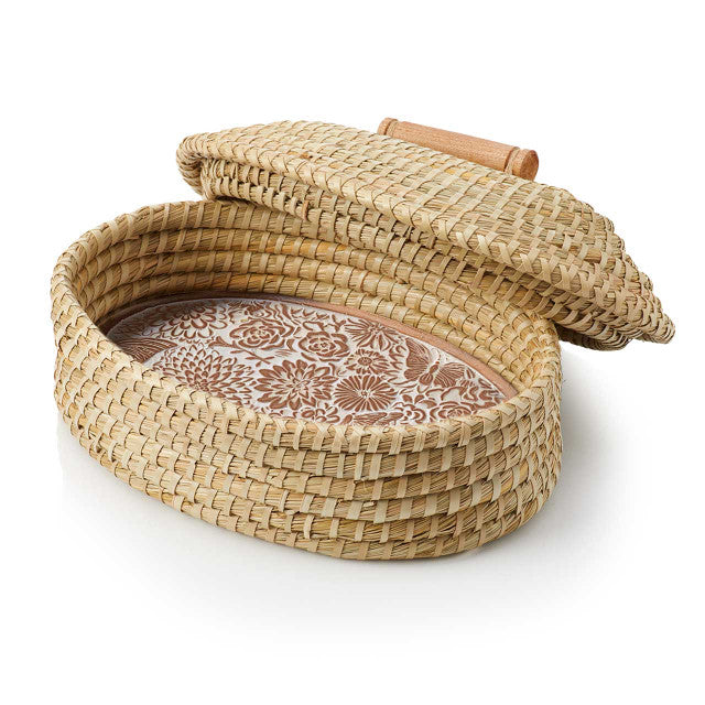 Woven basket with a floral patterned interior bread warmer on a white background