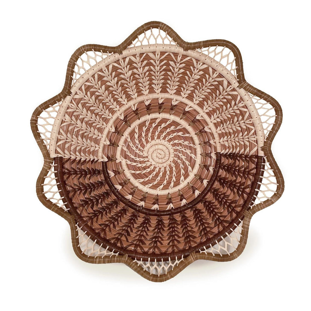 Decorative woven basket with intricate patterns on a white background