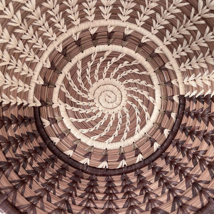Close-up of a handmade woven basket with a spiral pattern